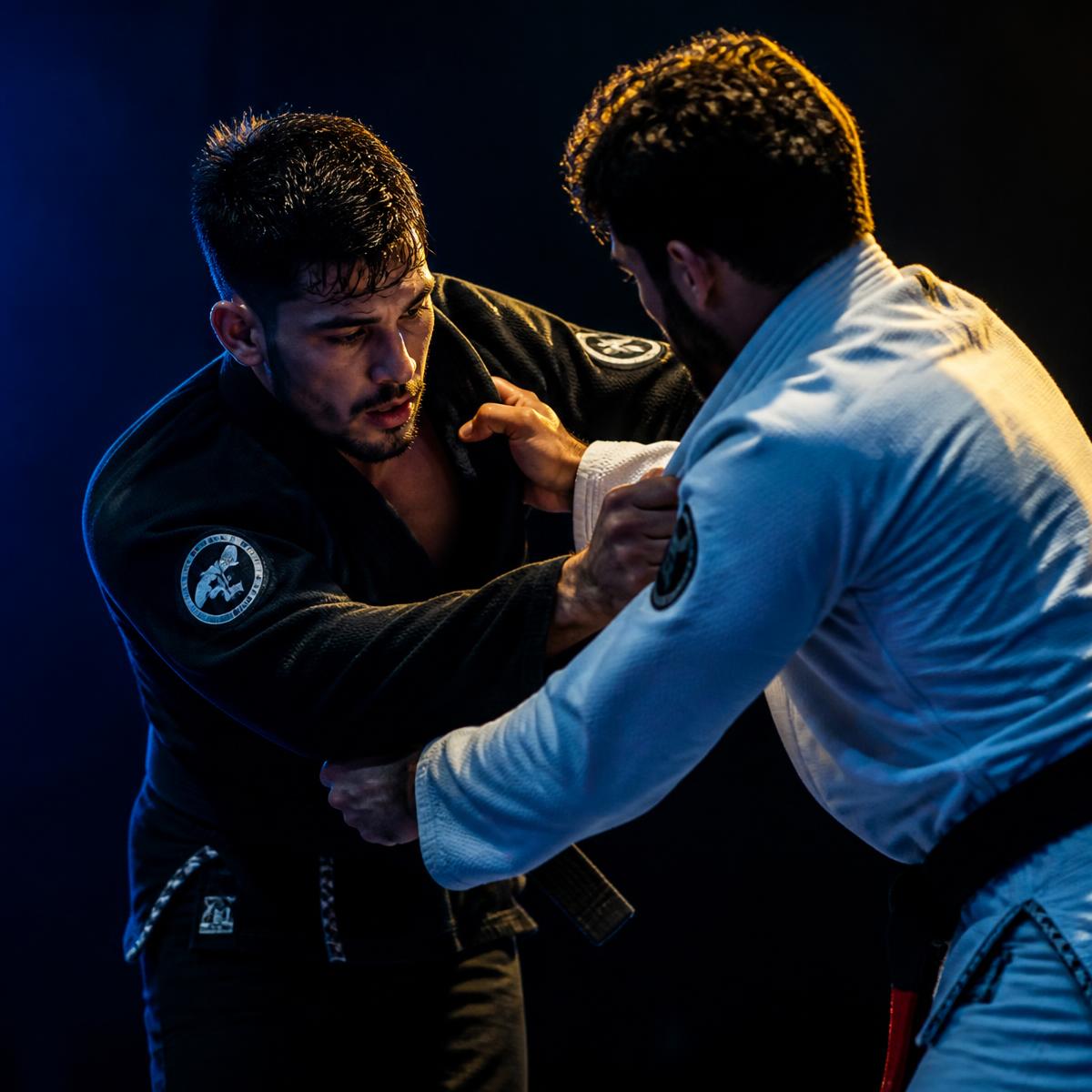 Dois atletas de jiu-jitsu disputando a pegada no quimono durante uma luta